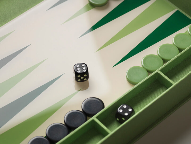 A backgammon board with green and black checkers, two dice showing five and four, and a green playing surface.