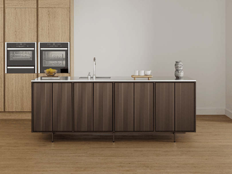 Modern minimalist kitchen featuring a Vipp wood-paneled island, built-in ovens, a sink, and minimal decor on a light wood floor.